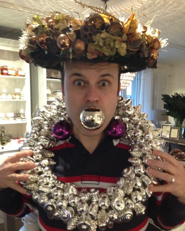 Der Moderator mit Weihnachtsschmuck auf dem Kopf, um den Hals und einer Weihnachtskugel im Mund. Der Moderator mit Weihnachtsschmuck auf dem Kopf, um den Hals und einer Weihnachtskugel im Mund.