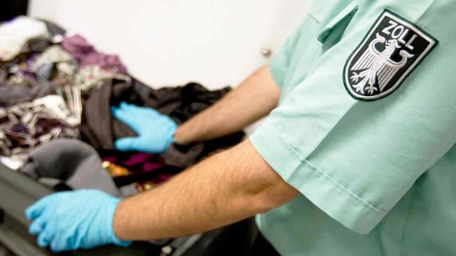 Zöllner untersucht Gepäck Zöllner untersucht Gepäck