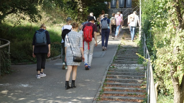 Eine Gruppe Menschen, die einen Gehweg entlang spaziert Eine Gruppe Menschen, die einen Gehweg entlang spaziert