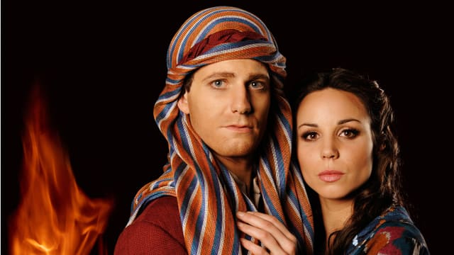 Die Musicaldarsteller der Figuren Moses und Ziphora in Kostümen, im Hintergrund eine Flamme. Die Musicaldarsteller der Figuren Moses und Ziphora in Kostümen, im Hintergrund eine Flamme.