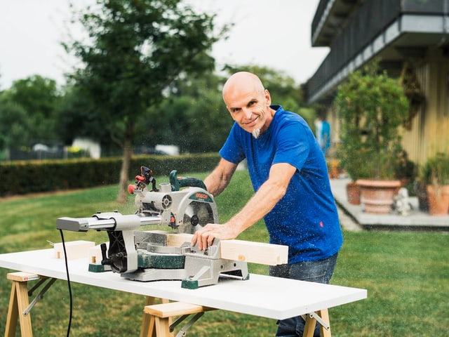 Kurt arbeitet mit seiner Sägemaschine im Freien. Kurt arbeitet mit seiner Sägemaschine im Freien.