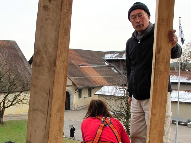 Der japanische Künstler Tadashi Kawamata und zwei Helfer auf dem Holzberg. Der japanische Künstler Tadashi Kawamata und zwei Helfer auf dem Holzberg.
