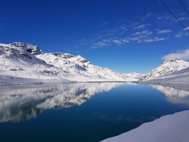 Der Stausee im Berniangebiet ist noch nicht zugefroren, die Berge rund um sind mitNeu schee bedeckt. Der Stausee im Berniangebiet ist noch nicht zugefroren, die Berge rund um sind mitNeu schee bedeckt.