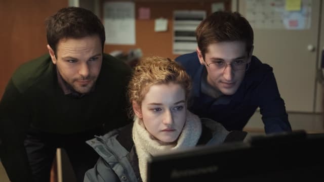 Jane an ihrem Bürotisch mit zwei männlichen Kollegen im Nacken. Jane an ihrem Bürotisch mit zwei männlichen Kollegen im Nacken.