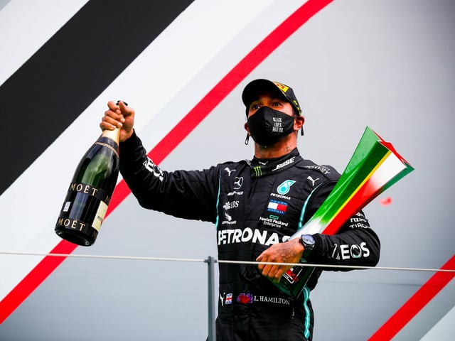 Lewis Hamilton mit Pokal und Schampus. Lewis Hamilton mit Pokal und Schampus.