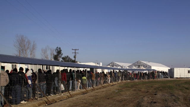 Flüchtlinge stehen am Grenzübergang bei Idomeni an Flüchtlinge stehen am Grenzübergang bei Idomeni an
