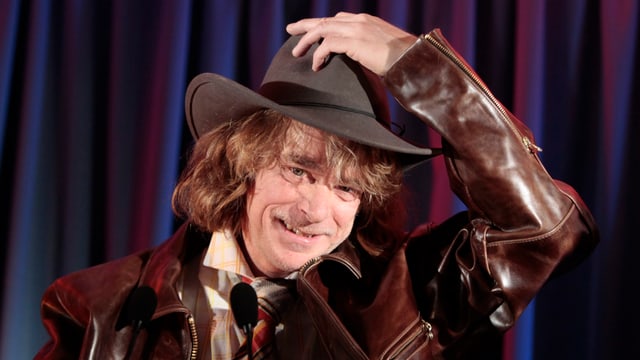 Helge Schneider mit schwarzem Hut im Rahmen des Programms «Buxe voll» (2010). Helge Schneider mit schwarzem Hut im Rahmen des Programms «Buxe voll» (2010).