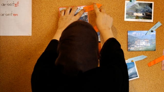 Eine Frau mit Kopftuch an einer Wandtafel Eine Frau mit Kopftuch an einer Wandtafel