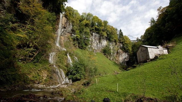 Fallenbach, Wasserfall, daneben Wiesen und eine kleine Hütte. Fallenbach, Wasserfall, daneben Wiesen und eine kleine Hütte.