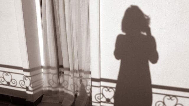 Schatten im Sonnen Gegenlicht einer Frau auf einem Balkon Schatten im Sonnen Gegenlicht einer Frau auf einem Balkon