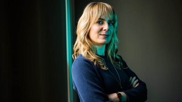 Anna Pieri Zuercher steht an einer Wand. Sie trägt einen blauen Pullover. Anna Pieri Zuercher steht an einer Wand. Sie trägt einen blauen Pullover.
