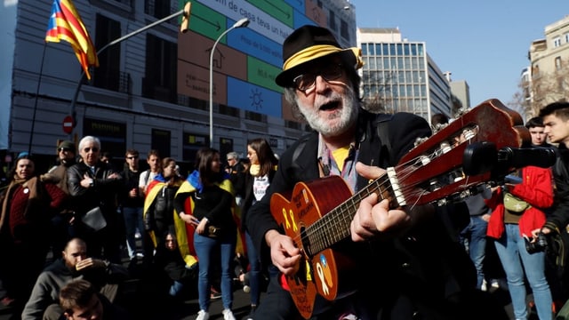 Ein Demonstrant in Barcelona spielt Gitarre.