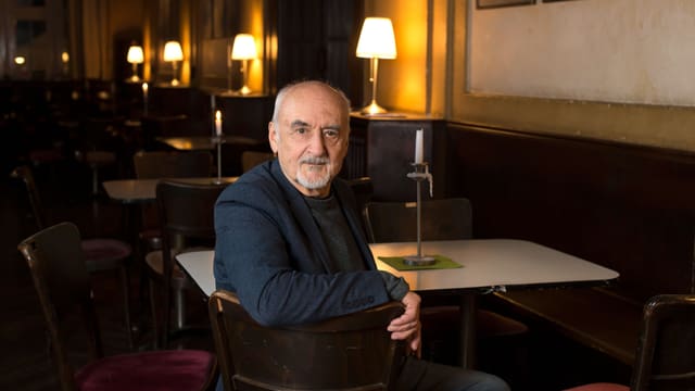 Ein älterer Herr sitzt in einem Restaurant. Ein älterer Herr sitzt in einem Restaurant.