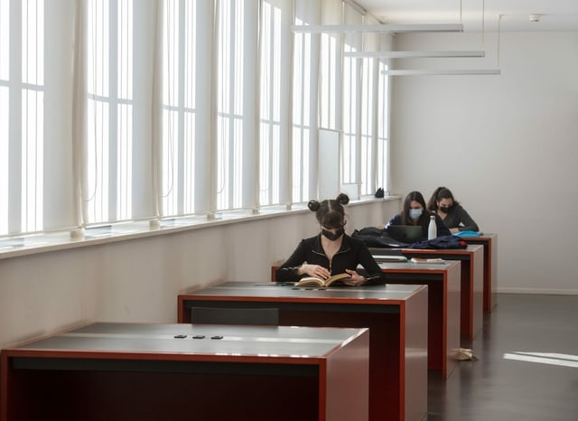 Drei Schülerinnen sitzen an den Schreibtischen der Kantonsbibliothek Lugano
