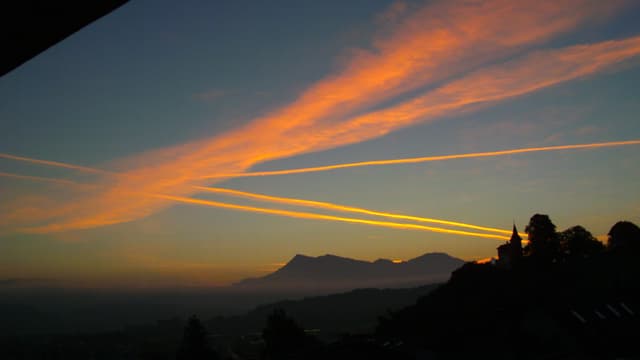 Zahlreiche orange Kondensstreifen am Himmel über Kriens. Zahlreiche orange Kondensstreifen am Himmel über Kriens.