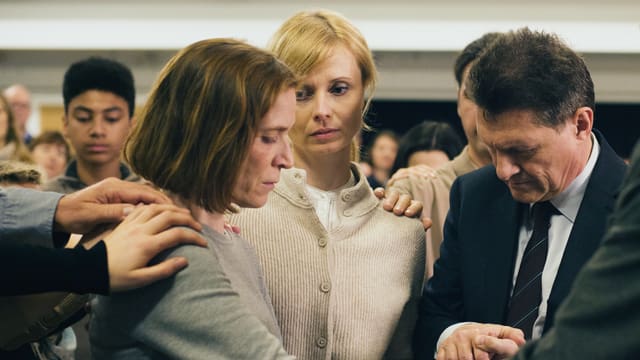 Ruth (Judith Hofmann) wird im Kreis einer Freikirche von diversen Händen berührt. Ruth (Judith Hofmann) wird im Kreis einer Freikirche von diversen Händen berührt.