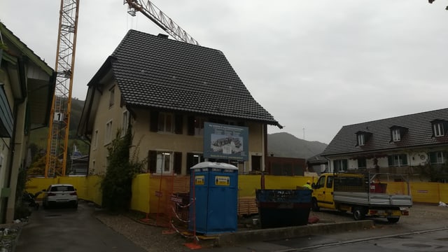Haus mit Kran und Bauabschrankungen. Haus mit Kran und Bauabschrankungen.