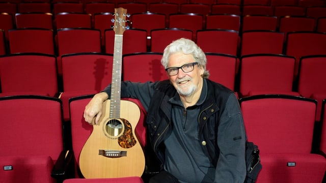 Musiker Jeff Turner sitzend mit Gitarre Musiker Jeff Turner sitzend mit Gitarre