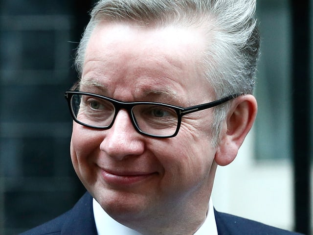 Ein Mann mit kurzem, grauem Haar und schwarzer Brille; er trägt einen Anzug mit Kravatte. Ein Mann mit kurzem, grauem Haar und schwarzer Brille; er trägt einen Anzug mit Kravatte.