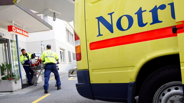 Sanitäter rollen einen Patienten aus einer Ambulanz. Sanitäter rollen einen Patienten aus einer Ambulanz.