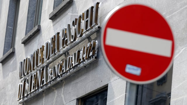 Logo von Monte dei Paschi an einem Bankgebäude, davor das Verkehrssignal verbotene Einfahrt. Logo von Monte dei Paschi an einem Bankgebäude, davor das Verkehrssignal verbotene Einfahrt.