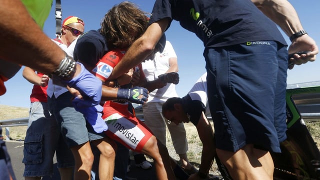 Helfer helfen Nairo Quintana nach dessen Sturz auf die Beine zurück. Helfer helfen Nairo Quintana nach dessen Sturz auf die Beine zurück.