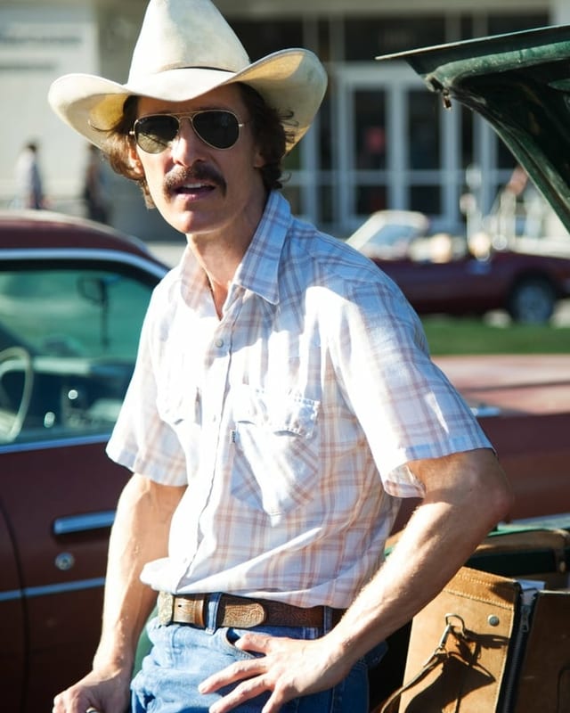 Mann mit Cowboy Hut und Brille posiert