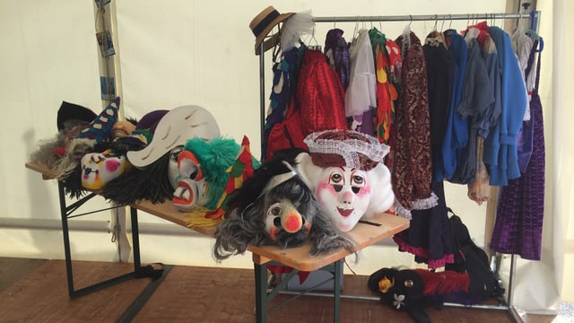 Ein Tisch mit traditionellen Fasnachtskostümen und Masken Ein Tisch mit traditionellen Fasnachtskostümen und Masken