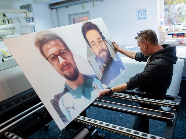 Die ersten "Pappkameraden" - Fans von Borussia Mönchengladbach - , die aus dem Drucker kommen, kontrolliert Thomas Heyer, Mitarbeiter einer Druckerei. Die Fans von Borussia Mönchengladbach wollen zu einer besseren Stimmung bei mögliche Geisterspiele in der Fußball-Bundesliga beitragen. Um den TV-Zuschauern und den Profis den Blick auf die leeren Stadion-Plätze zu ersparen, sollen Pappfiguren mit dem Konterfei der Anhänger in Lebensgröße aufgestellt werden