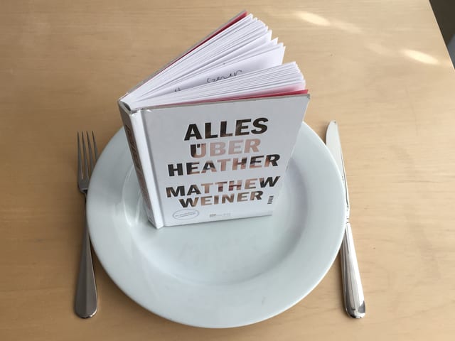 «Alles über Heather» von Matthew Weiner steht auf einem weissen Teller. Meser und Gabel daneben. «Alles über Heather» von Matthew Weiner steht auf einem weissen Teller. Meser und Gabel daneben.