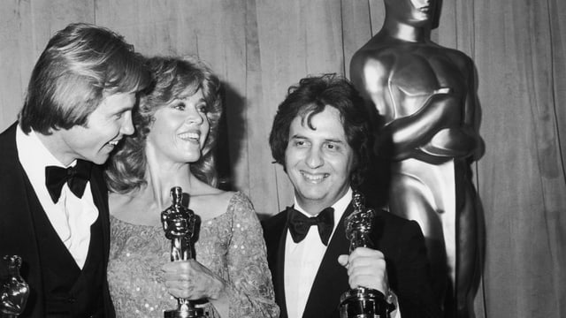 Zwei Männer und eine Frau halten die Oscar-Statue Zwei Männer und eine Frau halten die Oscar-Statue