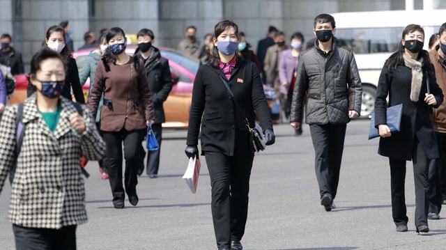 Nordkoreanerinnen und Nordkoreaner tragen auf der Strasse Masken Nordkoreanerinnen und Nordkoreaner tragen auf der Strasse Masken