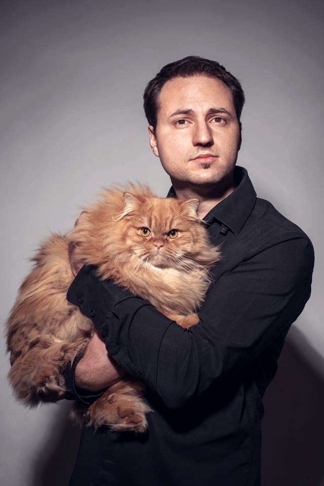Portrait von Alain Bieber, der eine Katze auf dem Arm hält. Portrait von Alain Bieber, der eine Katze auf dem Arm hält.