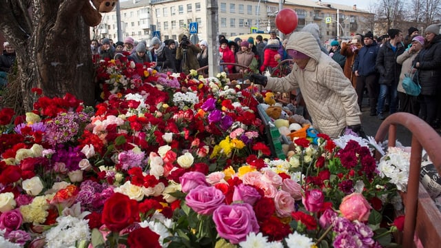Menschen legen Blumen für die Opfer nieder. Menschen legen Blumen für die Opfer nieder.
