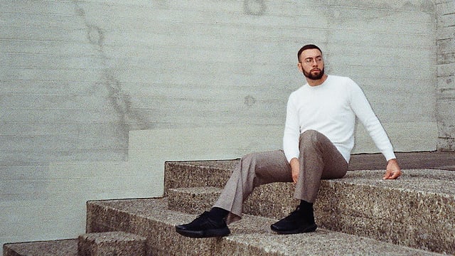 Ben Whale sitzt sinnierend auf einer Treppe Ben Whale sitzt sinnierend auf einer Treppe