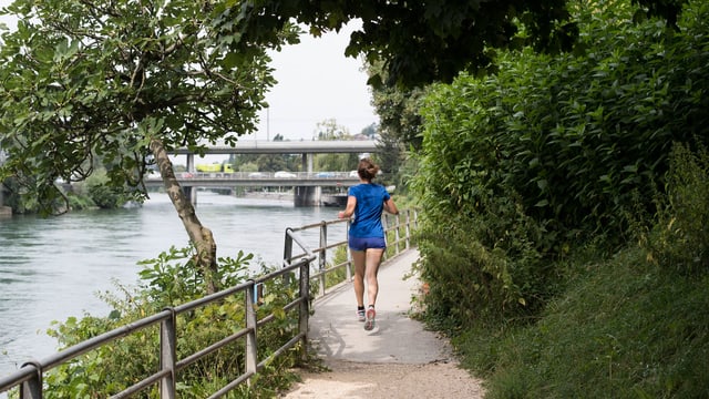 Eine Joggerin auf einem Laufweg entlang der Limmat. Eine Joggerin auf einem Laufweg entlang der Limmat.