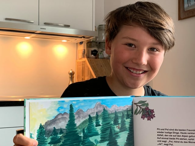 Ein Junge präsentiert sein Kinderbuch Ein Junge präsentiert sein Kinderbuch