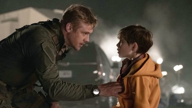 Ein Mann bpckt sich zu einem Jungen herunter. Er hält ihn an der Jacke und spricht mit ihm. Ein Mann bpckt sich zu einem Jungen herunter. Er hält ihn an der Jacke und spricht mit ihm.