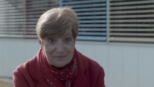 Frau in roten Mantel und kurzen Haaren schaut in die Kamera. Frau in roten Mantel und kurzen Haaren schaut in die Kamera.