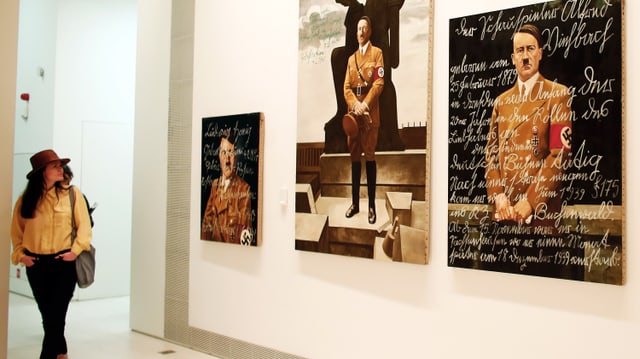 Bilder hängen in einem Ausstellungsraum an einer Wand. Bilder hängen in einem Ausstellungsraum an einer Wand.