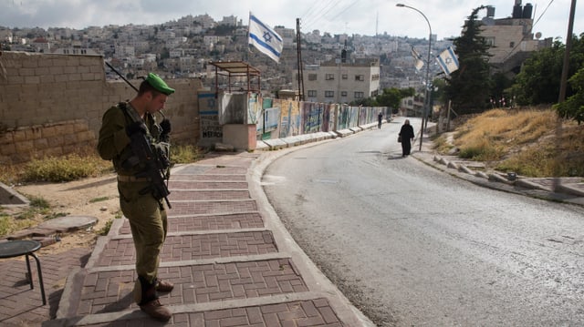 Ein israelischer Soldat bewacht eine jüdische Enklave in Hebron in der Westbank. Ein israelischer Soldat bewacht eine jüdische Enklave in Hebron in der Westbank.