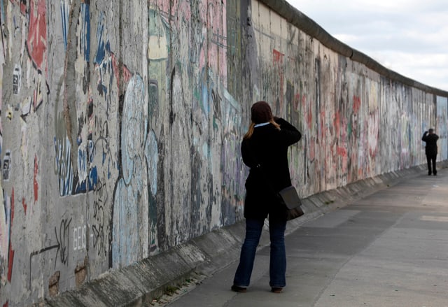 Eine Frau fotografiert die Berliner Mauer. Eine Frau fotografiert die Berliner Mauer.