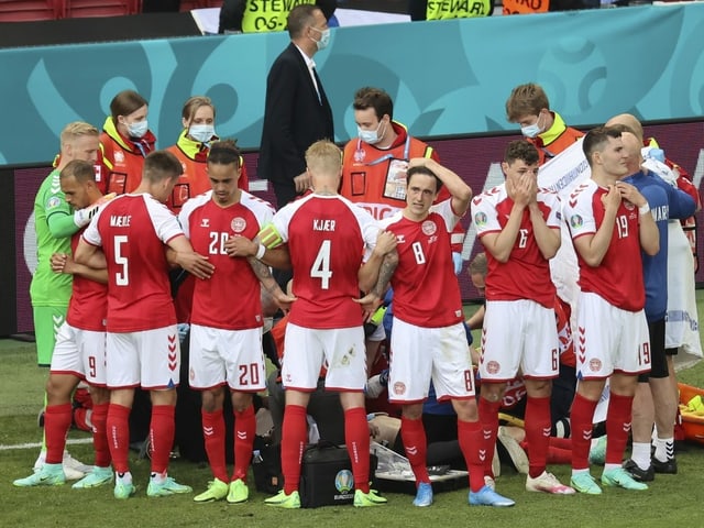 Die dänischen Nationalspieler bilden einen Kreis um Christian Eriksen. Die dänischen Nationalspieler bilden einen Kreis um Christian Eriksen.