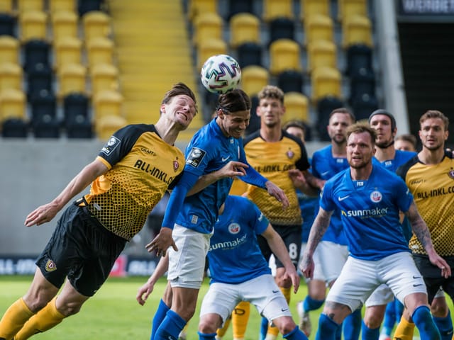 Dresdens Tim Knipping (l.) und Tobias Schwede (r.) von Hansa Rostock liefern sich in der 3. deutschen Liga ein Kopfball-Duell – und strahlen dabei um die Wette.