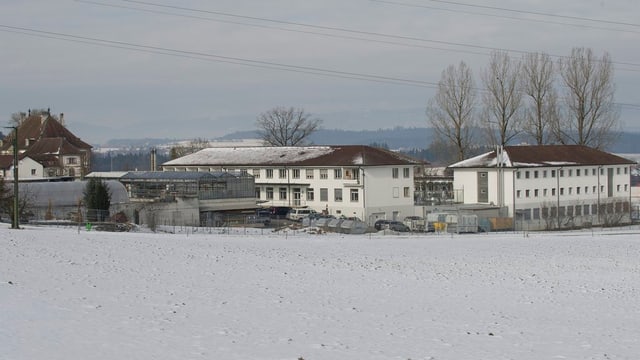 Blick auf zwei Gebäude der Anstalten Hindelbank, davor ein Feld mit Schnee. Blick auf zwei Gebäude der Anstalten Hindelbank, davor ein Feld mit Schnee.