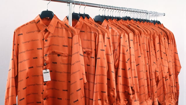 Orange Hemden auf einer Kleiderstange Orange Hemden auf einer Kleiderstange