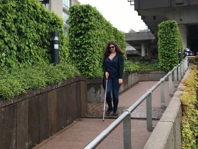 Luana Schena läuft mit ihrem weissen Stock eine Rampe auf dem Campus der Uni runter. Luana Schena läuft mit ihrem weissen Stock eine Rampe auf dem Campus der Uni runter.