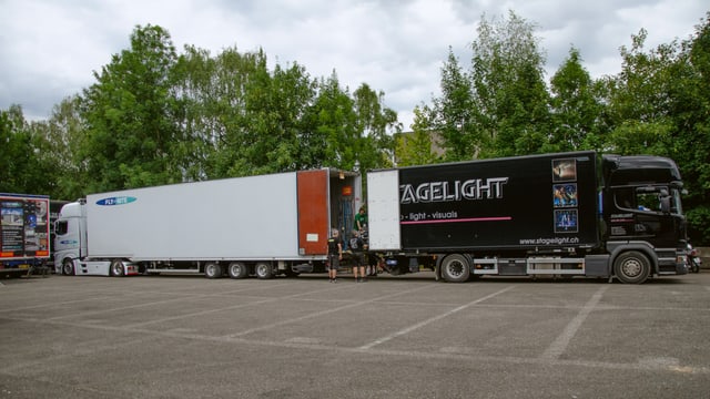 Die zwei Lastwagen in der Totale während dem Umladen Die zwei Lastwagen in der Totale während dem Umladen