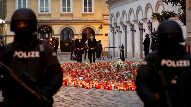 Zwei Polizisten bewachen den Tatort des Wiener Attentats, wo ein Kerzen- und Blumenmeer am Boden steht. Zwei Polizisten bewachen den Tatort des Wiener Attentats, wo ein Kerzen- und Blumenmeer am Boden steht.