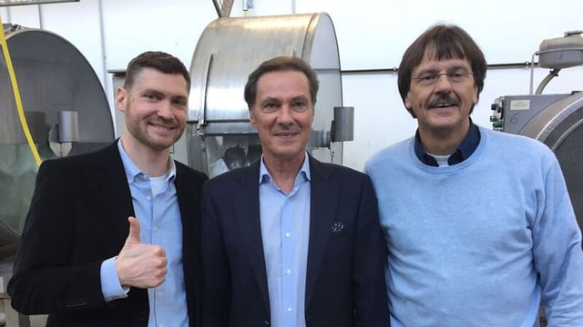 Drei Männer lächeln in die Kamera. Drei Männer lächeln in die Kamera.